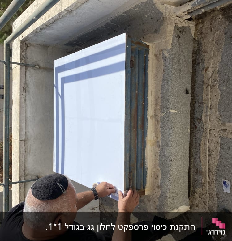 אדם מתקין לוח זכוכית על גג בטון